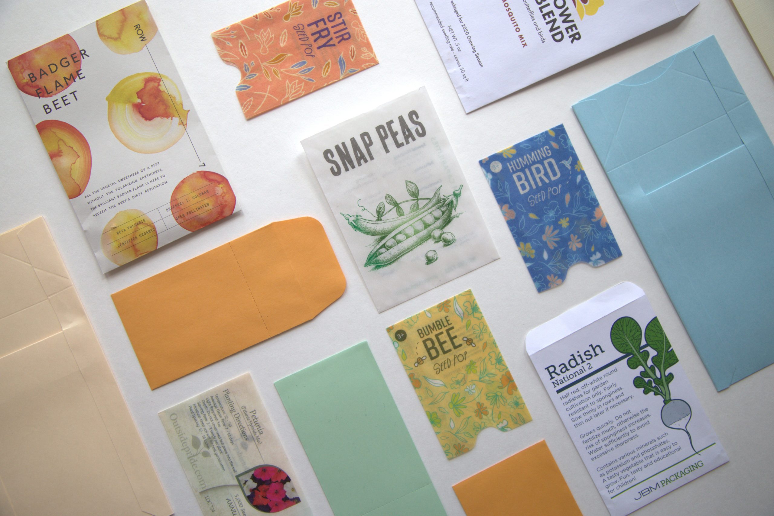 Seed packets, coin envelopes, and spear envelopes are arranged on a flat surface.