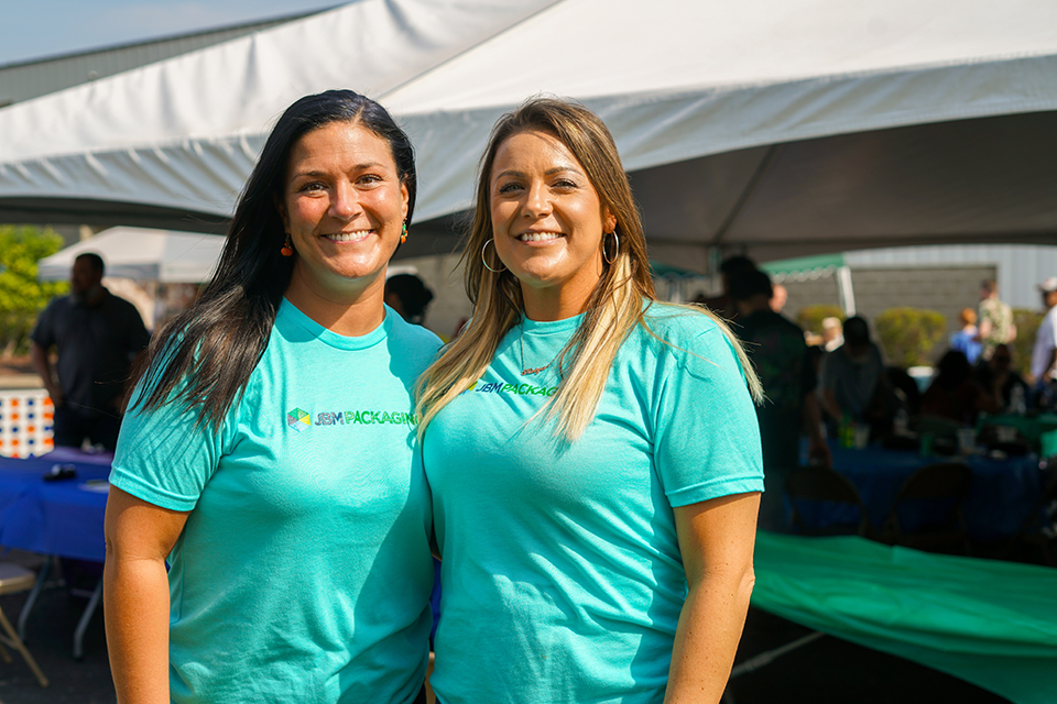 Two JBM team members smiling at a company event.