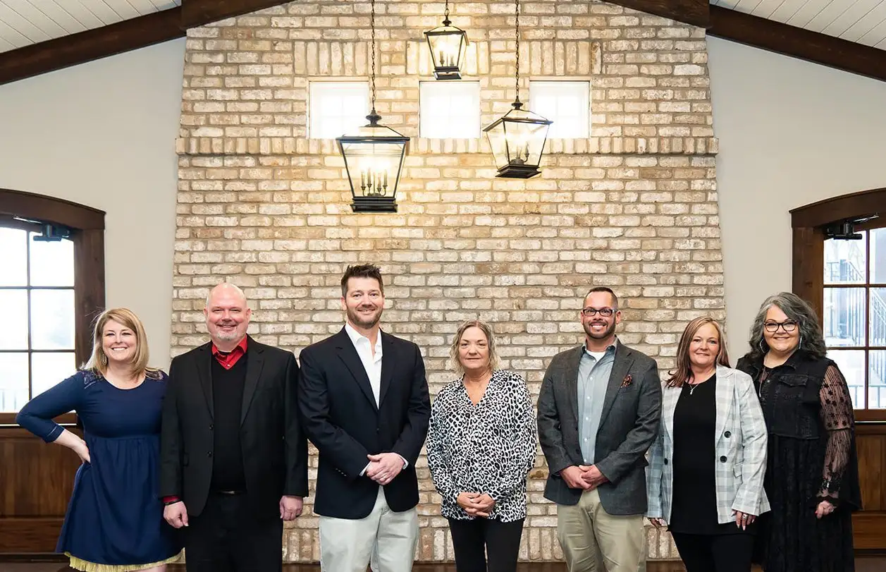 Seven individuals standing side by side, smiling.
