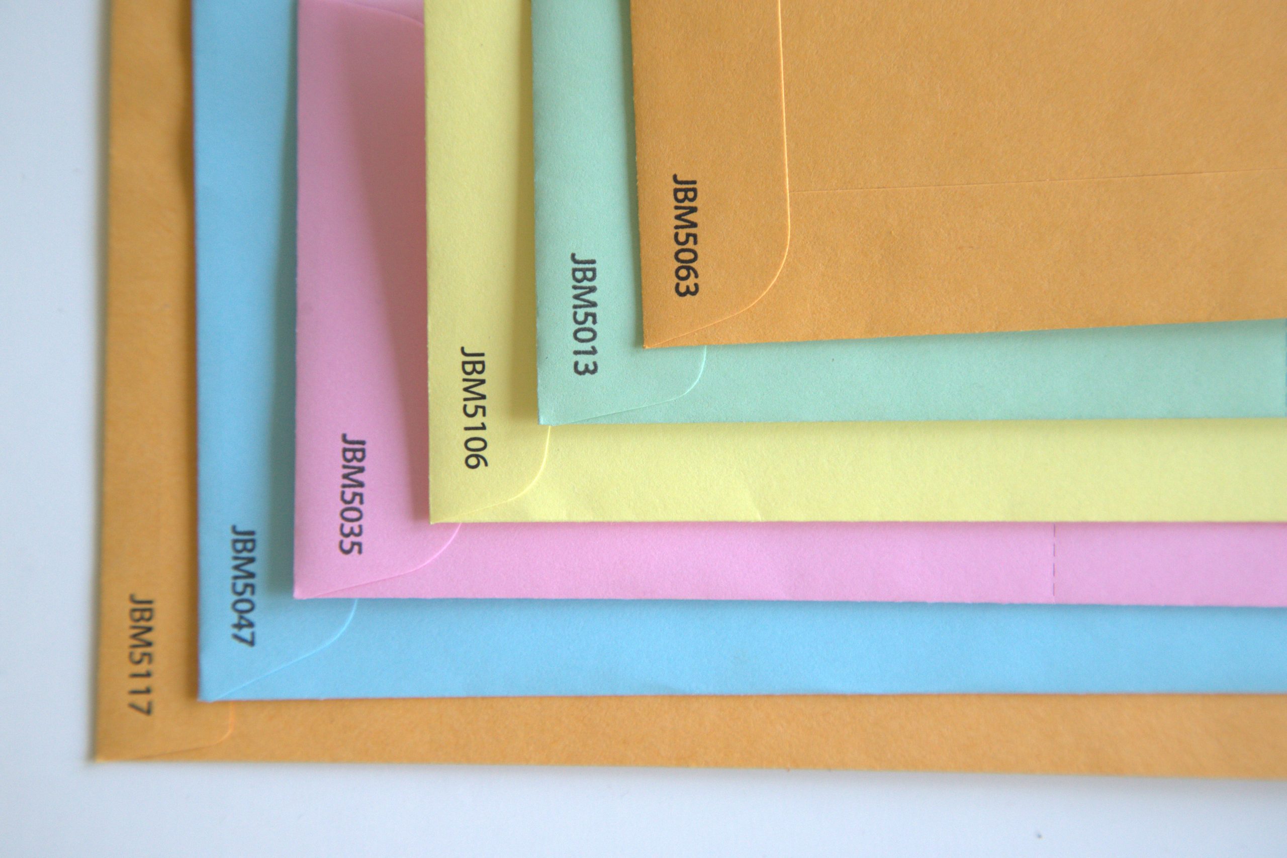 Six different-sized JBM-branded seed packet envelopes, featuring five different print colors and a secure seal closure.