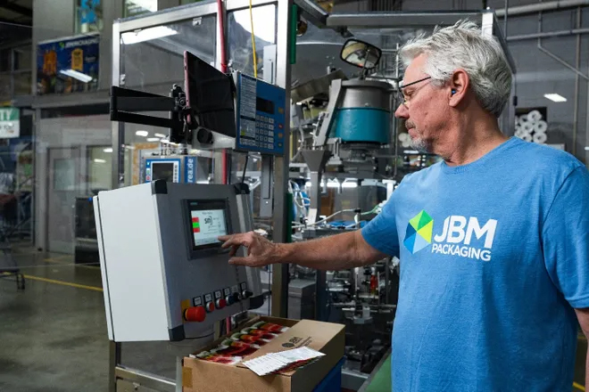JBM employee working on operating machinery in the warehouse for wholesale packaging fufillment services.