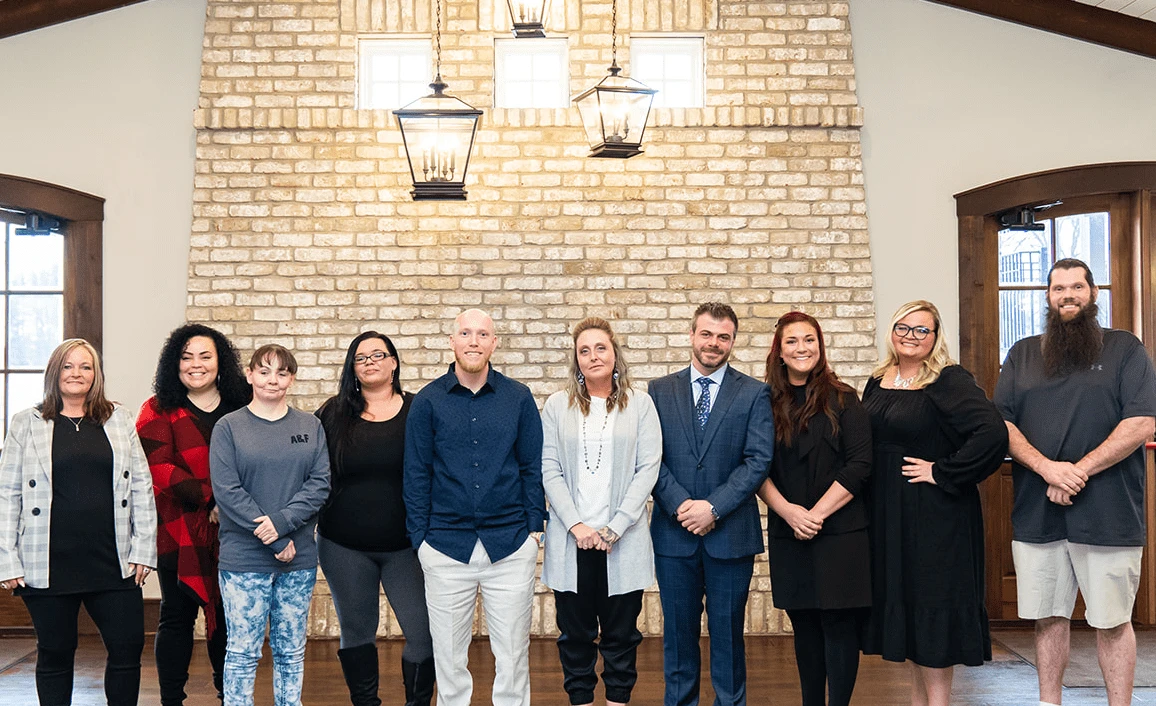 Ten individuals standing side by side, smiling.